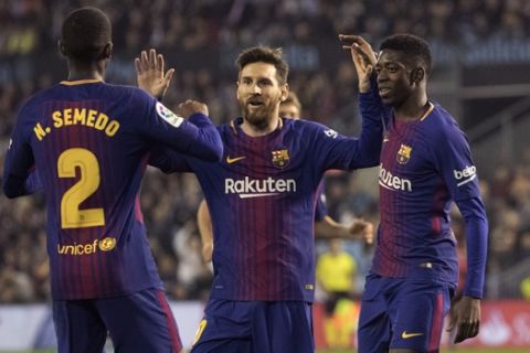 Barcelona's Nelson Semedo, left, Massi, center, and Ousmane Dembele celebrate after a second goal was scored, during a Spanish La Liga soccer match between RC Celta and Barcelona at the Balaidos stadium in Vigo, Spain, Tuesday April 17, 2018. (AP Photo/Lalo R. Villar)