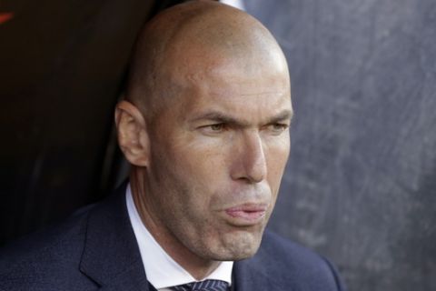 Real Madrid's coach Zinedine Zidane looks out from the bench before the start of a Spanish La Liga soccer match between Rayo Vallecano and Real Madrid at the Vallecas stadium in Madrid, Spain, Sunday, April 28, 2019. (AP Photo/Paul White)