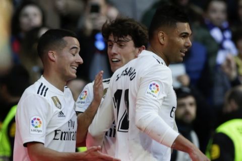 Real Madrid's Casemiro, right, celebrates with teammates Lucas Vazquez, left, and Alvaro Odriozola after scoring his team's first goal during a La Liga soccer match between Real Madrid and Girona at the Bernabeu stadium in Madrid, Spain, Sunday, Feb. 17, 2019. (AP Photo/Andrea Comas)