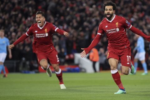 Liverpool's Mohamed Salah, center, celebrates scoring his side's first goal of the game during the Champions League quarter final first leg soccer match between Liverpool and Manchester City at Anfield stadium in Liverpool, England, Wednesday, April 4, 2018. (Peter Byrne/PA via AP)