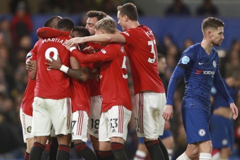 Manchester United's Anthony Martial, 9, is congratulated by teammates after scoring a goal during the English Premier League soccer match between Chelsea and Manchester United at Stamford Bridge in London, England, Monday, Feb. 17, 2020. (AP Photo/Ian Walton)