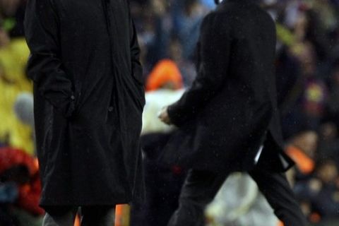 Real Madrid's coach Jose Mourinho (L) and Barcelona's coach Pep Guardiola react after Barcelona's second goal during their Spanish first division soccer match at Nou Camp stadium in Barcelona, November 29, 2010.    REUTERS/Albert Gea (SPAIN  - Tags: SPORT SOCCER)  