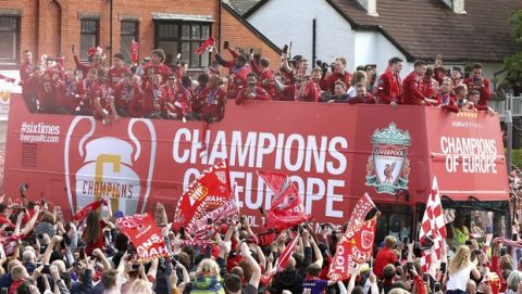 FAns look on as Liverpool soccer team and staff ride an open top bus during the Champions League Cup Winners Parade in Liverpool, England, Sunday June 2, 2019.  Liverpool is champion of Europe for a sixth time after beating Tottenham 2-0 in the Champions League final played in Madrid Saturday. (Barrington Coombs/PA via AP)