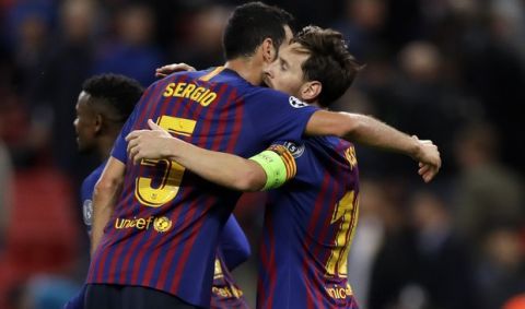 Barcelona forward Lionel Messi, right, celebrates with midfielder Sergio Busquets after scoring his side's fourth goal during the Champions League Group B soccer match between Tottenham Hotspur and Barcelona at Wembley Stadium in London, Wednesday, Oct. 3, 2018. (AP Photo/Kirsty Wigglesworth)