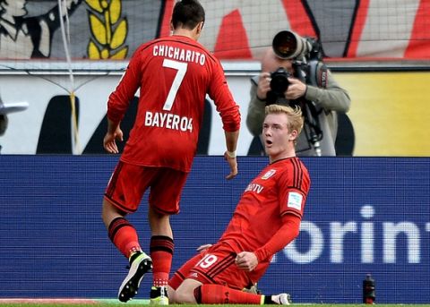 COLOGNE, NORTH RHINE-WESTPHALIA - APRIL 10:  Julian Brandt (R) of Leverkusen celebrates with team mate Chicharito after scoring the opening goal during the Bundesliga match between 1. FC Koeln and Bayer Leverkusen at RheinEnergieStadion on April 10, 2016 in Cologne, Germany.  (Photo by Sascha Steinbach/Bongarts/Getty Images)