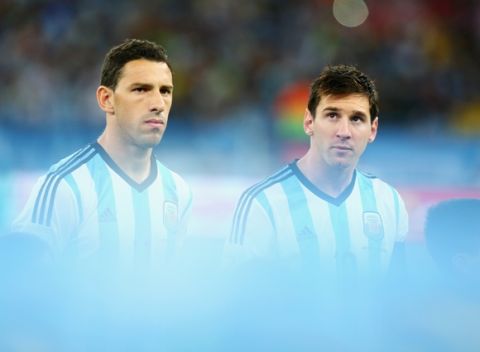 RIO DE JANEIRO, BRAZIL - JUNE 15:  Maxi Rodriguez (L) and Lionel Messi of Argentina look on during the National Anthems prior to the 2014 FIFA World Cup Brazil Group F match between Argentina and Bosnia-Herzegovina at Maracana on June 15, 2014 in Rio de Janeiro, Brazil.  (Photo by Ronald Martinez/Getty Images)