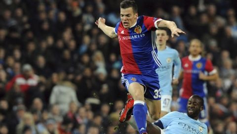 Basel's Kevin Bua, top, challenges for the ball with Manchester City's Yaya Toure during the Champions League, round of 16, second leg soccer match between Manchester City and Basel at the Etihad Stadium in Manchester, England, Wednesday, March 7, 2018. (AP Photo/Rui Vieira)