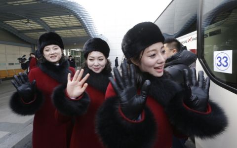 North Korean cheering squads wave upon their arrival at the Korean-transit office near the Demilitarized Zone in Paju, South Korea, Wednesday, Feb. 7, 2018. A North Korean delegation, including members of a state-trained cheering group, arrived in South Korea on Wednesday for the Pyeongchang Winter Olympics. (AP Photo/Ahn Young-joon. Pool)