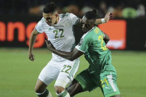 Algeria's Ismael Bennacer and Senegal's Lamine Gassama fight for the ball during the African Cup of Nations final soccer match between Algeria and Senegal in Cairo International stadium in Cairo, Egypt, Friday, July 19, 2019. (AP Photo/Hassan Ammar)
