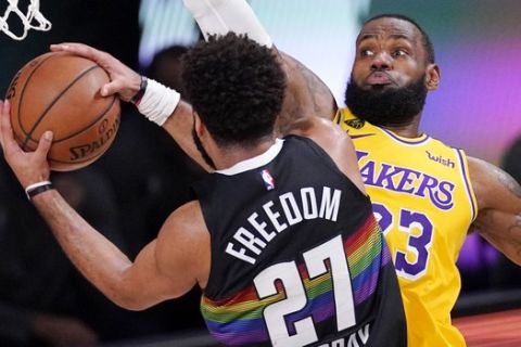 Denver Nuggets' Jamal Murray (27) drives against Los Angeles Lakers' LeBron James (23) and scores during the first half of an NBA conference final playoff basketball game Thursday, Sept. 24, 2020, in Lake Buena Vista, Fla. (AP Photo/Mark J. Terrill)