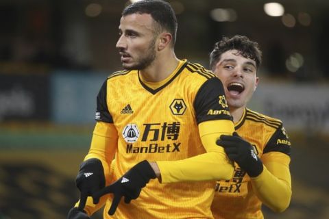 Wolverhampton Wanderers' Romain Saiss, left, celebrates with a teammate after scoring his sides 1st goal of the game during the English Premier League soccer match between Wolverhampton Wanderers and Tottenham Hotspur at Molineux Stadium, in Woverhampton, England, Sunday, Dec. 27, 2020. (Carl Recine/ Pool via AP)