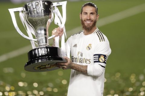 Real Madrid's captain Sergio Ramos lifts the trophy as he celebrates after winning the Spanish La Liga 2019-2020 following a soccer match between Real Madrid and Villareal at the Alfredo di Stefano stadium in Madrid, Spain, Thursday, July 16, 2020. (AP Photo/Bernat Armangue)