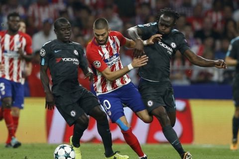 Chelsea's N'golo Kante, left, and his teammate Victor Moses try to stop Atletico's Yannick Carrasco during a Group C Champions League soccer match between Atletico Madrid and Chelsea at the Wanda Metropolitano stadium in Madrid, Spain, Wednesday Sept. 27, 2017. (AP Photo/Paul White)