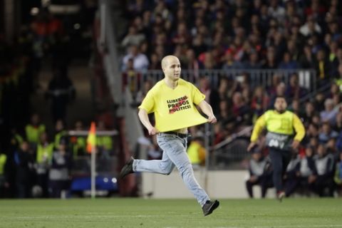 A man with Catalan on his T-shirt that reads "freedom for political prisoners", runs onto the field during the Champions League semifinal, first leg, soccer match between FC Barcelona and Liverpool at the Camp Nou stadium in Barcelona, Spain, Wednesday, May 1, 2019. (AP Photo/Emilio Morenatti)
