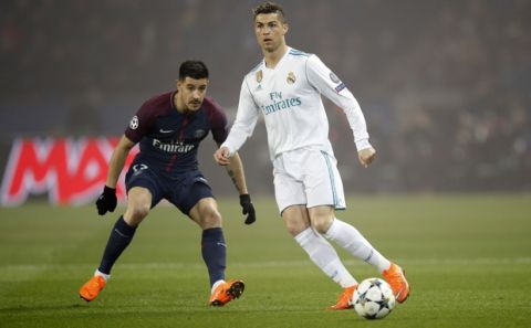 Real Madrid's Cristiano Ronaldo, right, and PSG's Yuri Berchiche, left, vie for the ball during the Champions League round of sixteen second leg soccer match between Paris St. Germain and Real Madrid at the Parc des Princes stadium in Paris, France, Tuesday, March 6, 2018. (AP Photo/Christophe Ena)