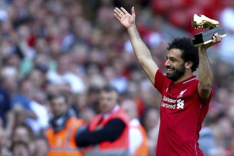 Liverpool's Mohamed Salah lifts up his golden boot award after the English Premier League soccer match against Brighton & Hove Albion at Anfield, Liverpool, England, Sunday, May 13, 2018. (Dave Thompson/PA via AP)