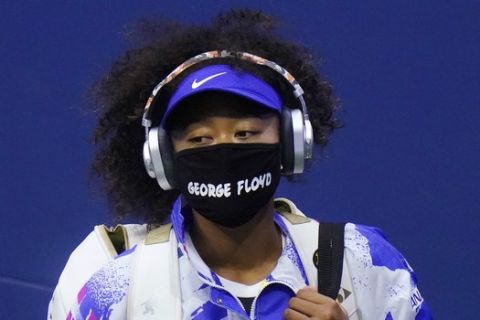 Naomi Osaka, of Japan, wears a protective mask due to the COVID-19 virus outbreak, featuring the name "George Floyd", while arriving on court to face Shelby Rogers, of the United States, during the quarterfinal round of the US Open tennis championships, Tuesday, Sept. 8, 2020, in New York. (AP Photo/Frank Franklin II)