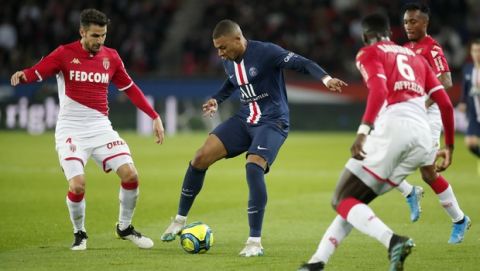 PSG's Kylian Mbappe, center, is challenged by Monaco's Tiemoue Bakayoko, right, and Monaco's Cesc Fabregas, left, during the French League One soccer match between Paris-Saint-Germain and Monaco at the Parc des Princes stadium in Paris, Sunday Jan. 12, 2020. (AP Photo/Francois Mori)