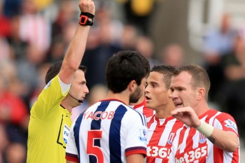 Match referee Michael Oliver (left) gives a red card to Stoke City's Ibrahim Afellay (no14) during the Barclays Premier League match at The Britannia Stadium, Stoke-upon-Trent. PRESS ASSOCIATION Photo. Picture date: Saturday August 29, 2015. See PA story SOCCER Stoke. Photo credit should read: Mike Egerton/PA Wire. RESTRICTIONS: EDITORIAL USE ONLY No use with unauthorised audio, video, data, fixture lists, club/league logos or "live" services. Online in-match use limited to 45 images, no video emulation. No use in betting, games or single club/league/player publications.