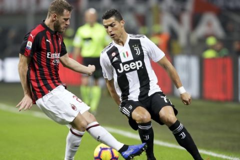 FILE - In this Sunday, Nov. 11, 2018 file photo, AC Milan's Ignazio Abate , left, and Juventus' Cristiano Ronaldo fight for the ball during a Serie A soccer match between AC Milan and Juventus, at Milan's San Siro stadium, Italy. Serie A has announced details of the Italian Super Cup to be played in Saudi Arabia next month despite calls for the game to be moved after the killing of Washington Post columnist Jamal Khashoggi. The match between Juventus and AC Milan is slated to be played Jan. 16 at the King Abdullah Sports City Stadium in Jeddah. (AP Photo/Luca Bruno, File )