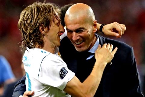 Real Madrid coach Zinedine Zidane, right, celebrates with Luka Modric after winning the Champions League Final soccer match between Real Madrid and Liverpool at the Olimpiyskiy Stadium in Kiev, Ukraine, Saturday, May 26, 2018. (AP Photo/Sergei Grits)
