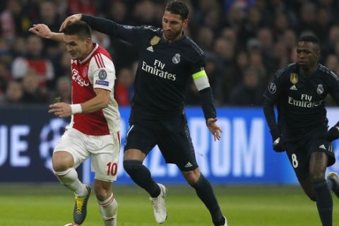 Ajax's Dusan Tadic, left, fights for the ball with Real defender Sergio Ramos during the first leg, round of sixteen, Champions League soccer match between Ajax and Real Madrid at the Johan Cruyff ArenA in Amsterdam, Netherlands, Wednesday Feb. 13, 2019. (AP Photo/Peter Dejong)