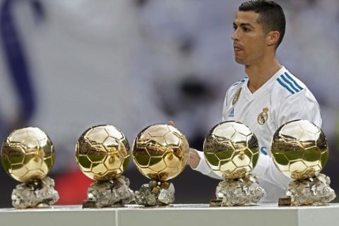 Real Madrid's Cristiano Ronaldo poses for the media with his five Golden Ball trophies prior the Spanish La Liga soccer match between Real Madrid and Sevilla at the Santiago Bernabeu stadium in Madrid, Saturday, Dec. 9, 2017. (AP Photo/Francisco Seco)