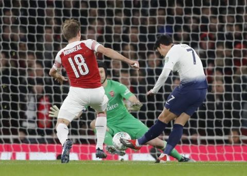 Tottenham's Son Heung-min, right, scores his side's first goal during the English League Cup quarter final soccer match between Arsenal and Tottenham Hotspur at the Emirates stadium in London, Wednesday, Dec. 19, 2018. (AP Photo/Frank Augstein)
