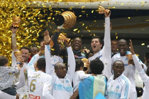 Marseille's French goalkepper Steve Mandanda, holds the trophy with teammates to celebrate their 1-0 victory against Montpellier, during the French League Cup Final at the Stade de France stadium in Saint Denis, outside of Paris, Saturday, April 23, 2011. (AP Photo/Claude Paris)