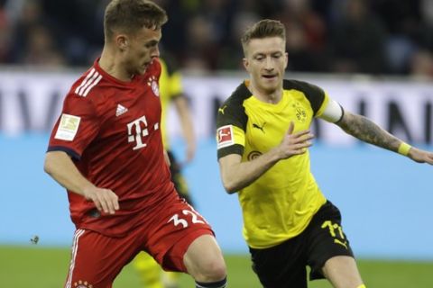 Bayern's Joshua Kimmich, left, and Dortmund's Marco Reus challenge for the ball during a German Bundesliga soccer match between Bayern Munich and Borussia Dortmund in Munich, Germany, Saturday, April 6, 2019. (AP Photo/Michael Probst)