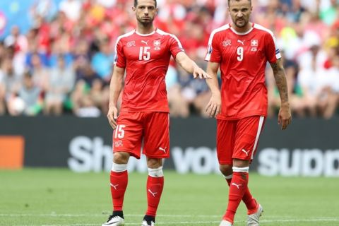 Switzerland's Blerim Dzemaili, left, and  Haris Seferovic stand on the pitch during the Euro 2016 round of 16 soccer match between Switzerland and Poland, at the Geoffroy Guichard stadium in Saint-Etienne, France, Saturday, June 25, 2016. (AP Photo/Laurent Cipriani)