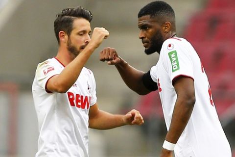 FC Cologne's Anthony Modeste, right, celebrates scoring their first goal with Mark Uth during a German Bundesliga soccer match between 1. FC Cologne and Fortuna Duesseldorf in Cologne, Germany, Sunday, May 24, 2020.  (Thilo Schmuelgen/pool via AP)