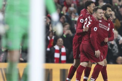 Liverpool's Xherdan Shaqiri, center, celebrates with teammates Mohamed Salah, right, after scoring his side's third goal during the English Premier League soccer match between Liverpool and Newcastle at Anfield Stadium, Liverpool, England, Wednesday, Dec. 26, 2018. (AP Photo/Jon Super)