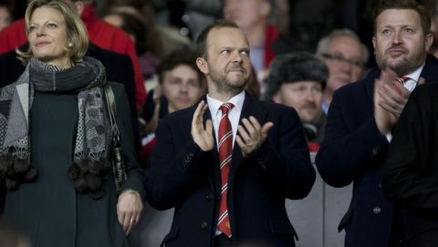 Manchester United chief executive Ed Woodward, centre, applauds before the team's English Premier League soccer match against Tottenham at Old Trafford Stadium, Manchester, England, Wednesday Jan. 1, 2014. (AP Photo/Jon Super)