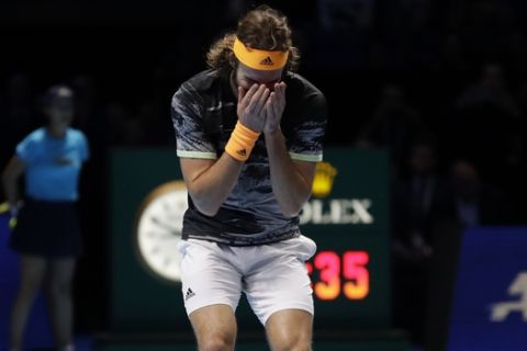 Stefanos Tsitsipas of Greece drops his racquet as he wins and defeats Austria's Dominic Thiem in their ATP World Finals singles final tennis match at the O2 arena in London, Sunday, Nov. 17, 2019. (AP Photo/Kirsty Wigglesworth)