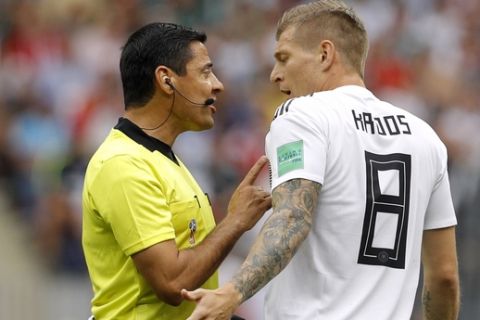 Referee Alireza Faghani talks to Germany's Toni Kroos, right, during the group F match between Germany and Mexico at the 2018 soccer World Cup in the Luzhniki Stadium in Moscow, Russia, Sunday, June 17, 2018. (AP Photo/Victor R. Caivano)