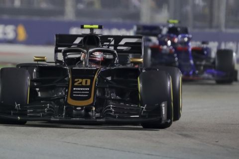 Haas driver Kevin Magnussen of Denmark steers his car ahead of Toro Rosso driver Pierre Gasly of France during the Singapore Formula One Grand Prix, at the Marina Bay City Circuit in Singapore, Sunday, Sept. 22, 2019. (AP Photo/Vincent Thian)