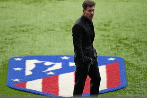 Atletico Madrid's head coach Diego Simeone stands by the club's official emblem waiting for the team to receive the trophy at the Wanda Metropolitano stadium in Madrid, Spain, Sunday, May 23, 2021. Atletico Madrid survived a dramatic final round to clinch its first Spanish league title since 2014 with a 2-1 come-from-behind win at Valladolid on Saturday. (AP Photo/Manu Fernandez)