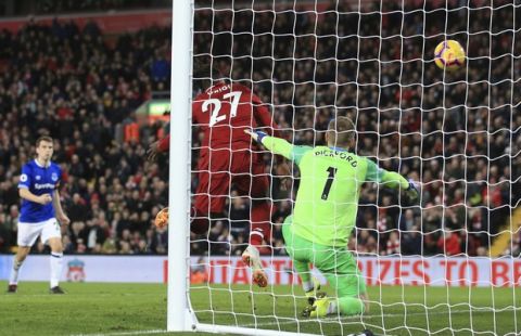 Liverpool forward Divock Origi, center, scores his side's first goal during the English Premier League soccer match between Liverpool and Everton at Anfield Stadium in Liverpool, England, Sunday, Dec. 2, 2018. (AP Photo/Jon Super)