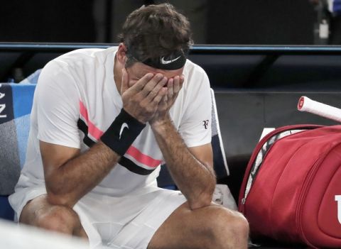 Switzerland's Roger Federer holds his head after defeating Croatia's Marin Cilic in the men's singles final at the Australian Open tennis championships in Melbourne, Australia, Sunday, Jan. 28, 2018. (AP Photo/Vincent Thian)