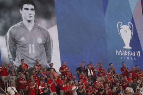 Liverpool fans stand beneath a poster of Jose Antonio Reyes during a minute of since for Reyes, the former Spain midfielder who was killed in a traffic accident at the age of 35 before the start of during the Champions League final soccer match between Tottenham Hotspur and Liverpool at the Wanda Metropolitano Stadium in Madrid, Saturday, June 1, 2019. (AP Photo/Bernat Armangue)