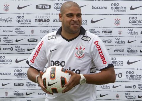 Brazilian soccer player Adriano poses for pictures during his presentation as the new striker of the Corinthians soccer club in Sao Paulo, Brazil, Thursday March, 31, 2011.  (AP Photo/Andre Penner)