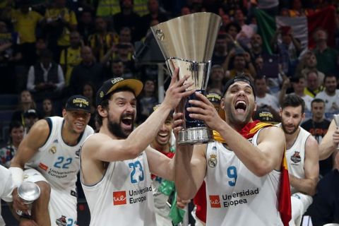 Real Madrid's Felipe Reyes, right, and Sergio Llull hold the trophy as the team celebrates their 85-80 win in the Final Four Euroleague final basketball match between Real Madrid and Fenerbahce Istanbul in Belgrade, Serbia, Sunday, May 20, 2018. (AP Photo/Darko Vojinovic)