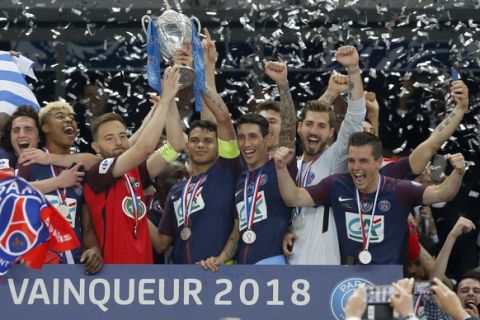 PSG captain Thiago Silva, center right, and Les Herbiers captain Sebastien Flochon, center left, lift the French Cup 2018 trophy with PSG players : Adrien Rabiot, left, Presnel Kimpembe, 2nd left, Angel Di Maria, 3rd right, PSG goalkeeper Kevin Trapp, 2nd right, and Giovani Lo Celso, right, during the trophy ceremony at the Stade de France stadium in Saint-Denis, outside Paris, Tuesday, May 8, 2018. Paris Saint-Germain beat resilient third-division side Les Herbiers 2-0 to win the French Cup. (AP Photo/Michel Euler) PSG's Presnel Kimpembe