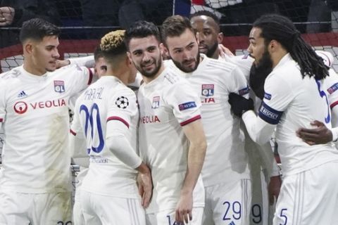 Lyon players celebrate with Lucas Tousart, center right with number 29, after he scored his side's first goal during a round of sixteen, first leg, soccer match between Lyon and Juventus at the at the Lyon Olympic Stadium in Decines, outside Lyon, France, Wednesday, Feb. 26, 2020. (AP Photo/Laurent Cipriani)
