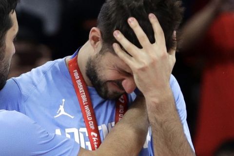 Facundo Campazzo of Argentina, left, hugs teammate Nicolas Laprovittola during the silver-medal ceremony after their loss to Spain in their first-place match in the FIBA Basketball World Cup at the Cadillac Arena in Beijing, Sunday, Sept. 15, 2019. (AP Photo/Mark Schiefelbein)