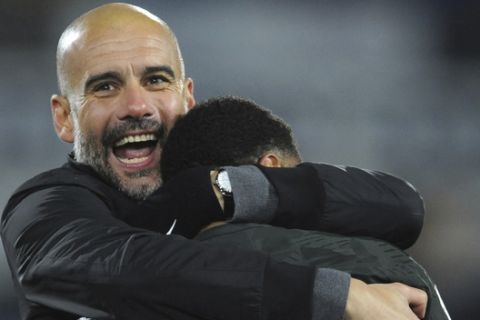 Manchester City manager Josep Guardiola, left, celebrates with goal scorer Manchester City's Raheem Sterling after the final whistle during the English Premier League soccer match between Huddersfield Town and Manchester City at John Smith's stadium, in Huddersfield, England, Sunday, Nov. 26, 2017. (AP Photo/Rui Vieira)