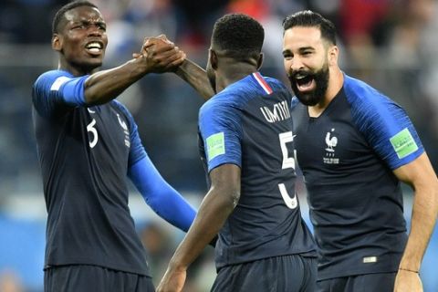 France's Paul Pogba, left, celebrates with Samuel Umtiti and Adil Rami after their team advanced to the final during the semifinal match between France and Belgium at the 2018 soccer World Cup in the St. Petersburg Stadium in St. Petersburg, Russia, Tuesday, July 10, 2018. (AP Photo/Martin Meissner)