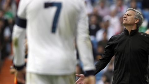 Real Madrid's coach Jose Mourinho from Portugal, right, gestures beside Cristiano Ronaldo from Portugal, partly seen, left, during a Spanish La Liga soccer match against Betis at the Santiago Bernabeu stadium in Madrid, Spain, Saturday, April 20, 2013. (AP Photo/Andres Kudacki)