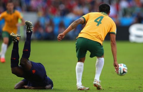 PORTO ALEGRE, BRAZIL - JUNE 18: Bruno Martins Indi of the Netherlands falls to the field after a challenge by Australia during the 2014 FIFA World Cup Brazil Group B match between Australia and Netherlands at Estadio Beira-Rio on June 18, 2014 in Porto Alegre, Brazil.  (Photo by Dean Mouhtaropoulos/Getty Images)